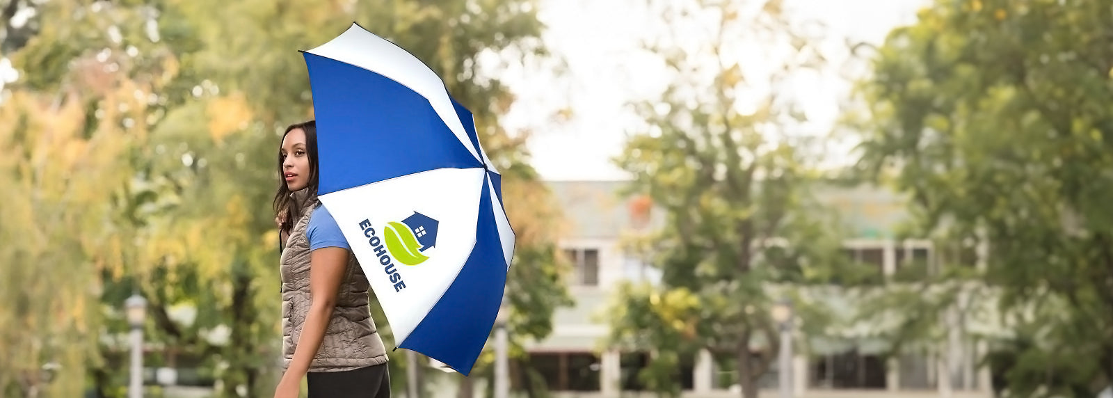 Woman standing on the road with a blue and white custom umbrella with logo printing for brand visibility